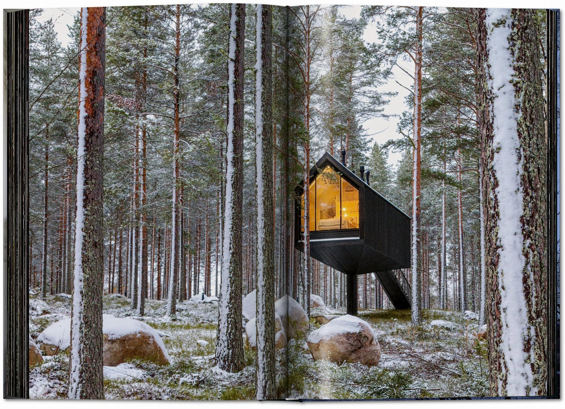 The TASCHEN Homes for Our Time: Small Houses (XL) book by TASCHEN showcases modern small cabins set among snowy trees, featuring large windows and cozy, sustainable living—perfect inspiration for winter retreats.