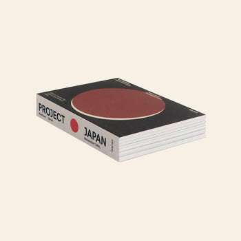 TASCHEN Project Japan: Metabolism Talks by TASCHEN, with a black cover featuring a large red circle and white text, focused on Metabolism architecture and urban design, rests closed on a light beige background.