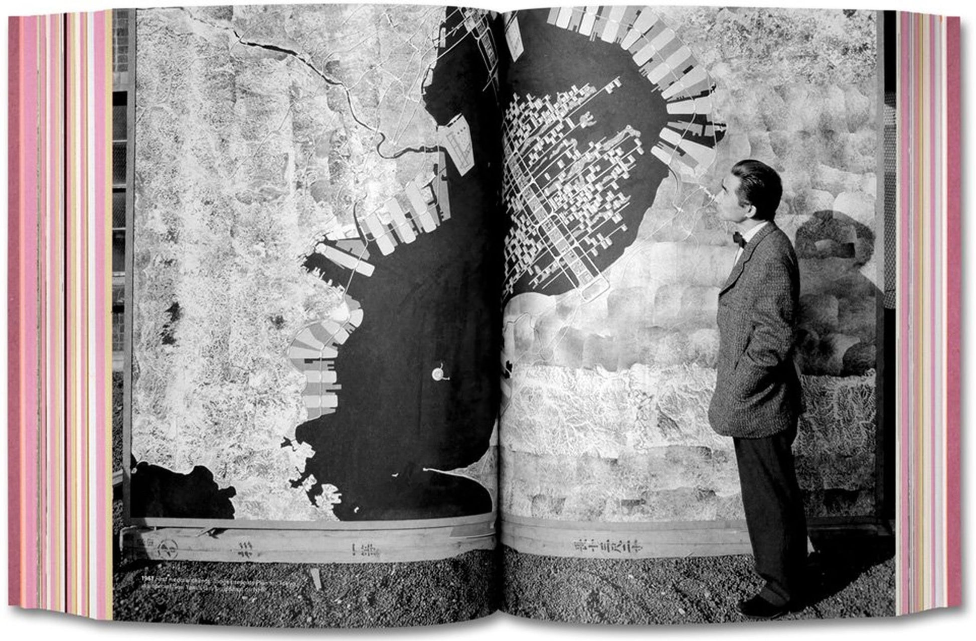A man in a suit observes a detailed map of a coastal city, featuring docks and waterfronts, spread across two pages of TASCHENs Project Japan: Metabolism Talks.