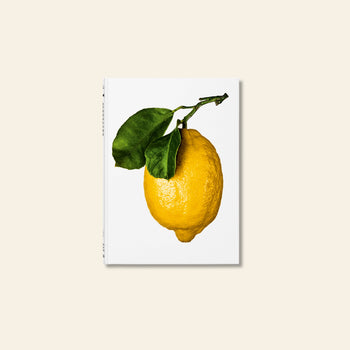 TASCHEN The Gourmands Lemon: A Collection of Stories and Recipes features a striking yellow lemon with green leaves on a white cover, ideal for lemon lovers and food enthusiasts. Book by TASCHEN, centered on a light beige surface.