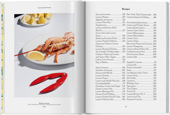 An open copy of TASCHEN The Gourmands Lemon shows a photo of lobster on a white plate with lemon wedges and a red crab cracker, alongside expert-created recipes like Savory Lemons and Lemon Risotto.