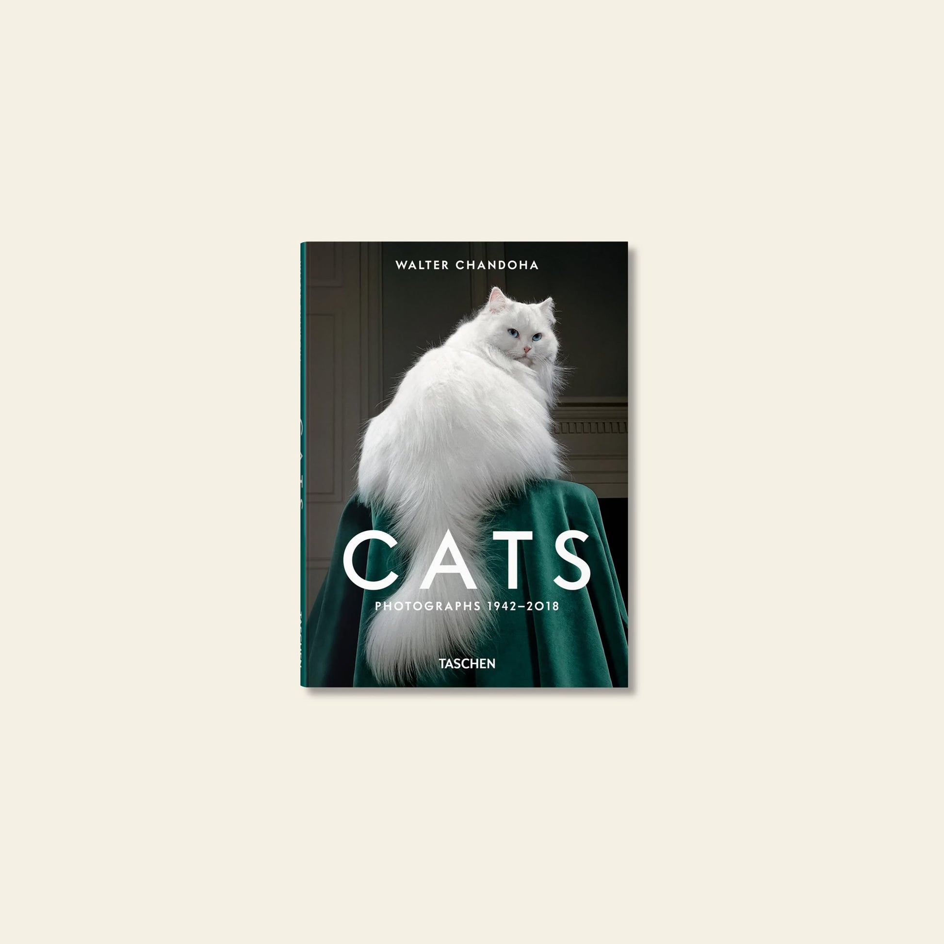 Book cover for TASCHEN Walter Chandoha. Cats. Photographs 1942-2018 by TASCHEN features a fluffy white cat on a green draped surface, sitting backward and glancing over its shoulder—a classic feline portrait.