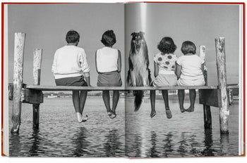 A black-and-white photo from TASCHEN Walter Chandoha. Dogs. Photographs 1941-1991 shows four children and a dog side by side on a wooden dock, gazing at calm water—a classic moment in dog photography by TASCHEN.