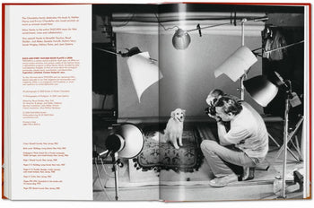 A pet photographer captures a white dog on a studio rug, with pro lighting in view. The open TASCHEN “Walter Chandoha. Dogs. Photographs 1941-1991” book shows text printed on the left page.