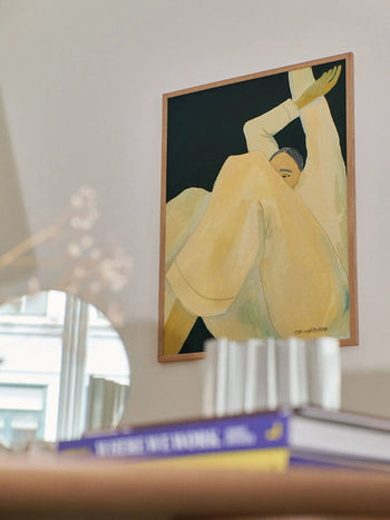 Hanna Petersons The Dream (30x40), from The Poster Club, is a fine art giclée print showing a person in light yellow with raised arms, framed above a desk with books, a mirror, and blurred decor.