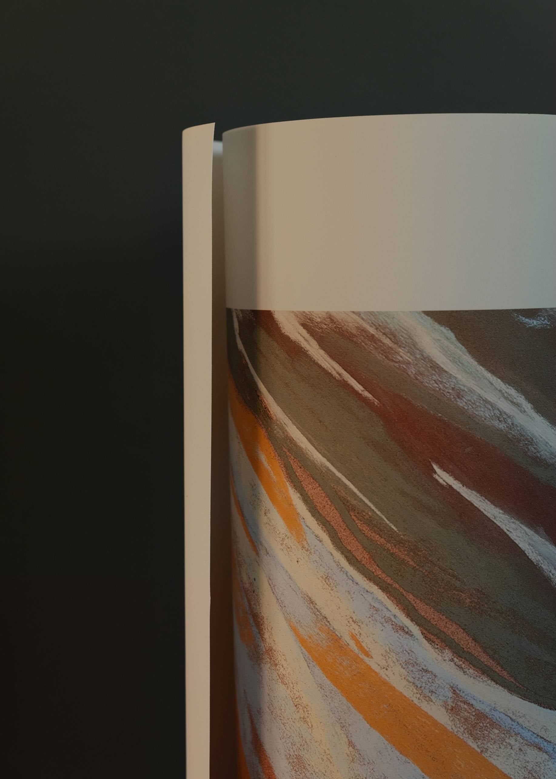 A close-up of The Poster Club Mandy Maria - Cuillin Ridge VII (50x70) shows a cylindrical object with a smooth white edge and abstract brown, orange, and white swirls set against a dark background.
