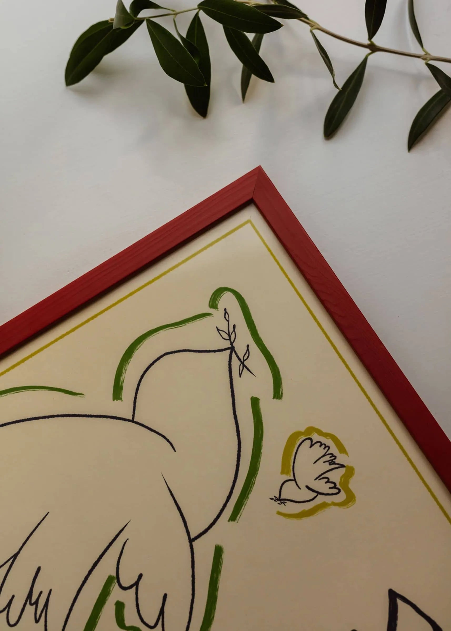 The Poster Club’s Feelings (30x40) by Marta Leyva is a framed minimalist Giclée print featuring a dove, a smaller bird, and olive branches on white, accented with a red border for a Mediterranean feel.