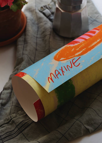 A colorful cup lies beside a potted plant and Bialetti coffee maker, echoing the aesthetic of The Poster Club’s “Maxine Mccrann - Bialetti And Clementines (50x70)” print.
