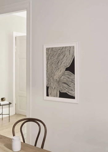 Minimalist interior with a wooden chair, small round table and The Poster Club’s Rebecca Hein - The Line No. 13 (30x40) art print displayed on a light wall, capturing nordic design next to an open doorway.
