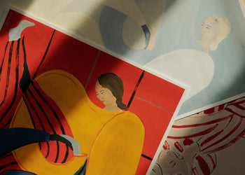 A close-up of three abstract art prints by Sofia Lind for The Poster Club, including Hold You - Red (50x70) with a vivid red and yellow background, and two others in soft blue and beige shades featuring stylized women.