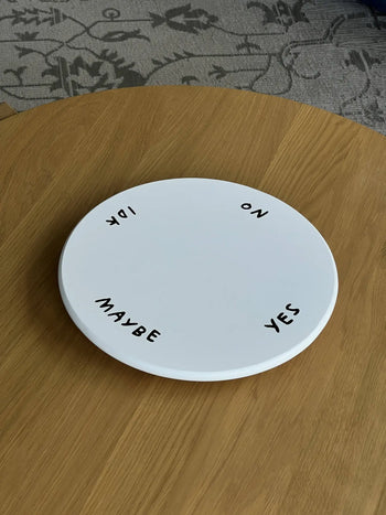 The Third Drawer Down Adam JK - Indecisive Lazy Susan features YES, NO, IDK, and MAYBE around its edge—a playful white round piece for decision-making moments by Third Drawer Down, inspired by Adam JK.