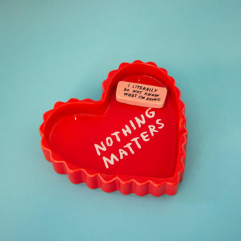 The Third Drawer Down Adam JK - Nothing Matters Ceramic Tray is a playful red heart-shaped piece with NOTHING MATTERS and a small pink plaque saying I LITERALLY DO NOT KNOW WHAT IM DOING—a quirky reminder to embrace the unknown.
