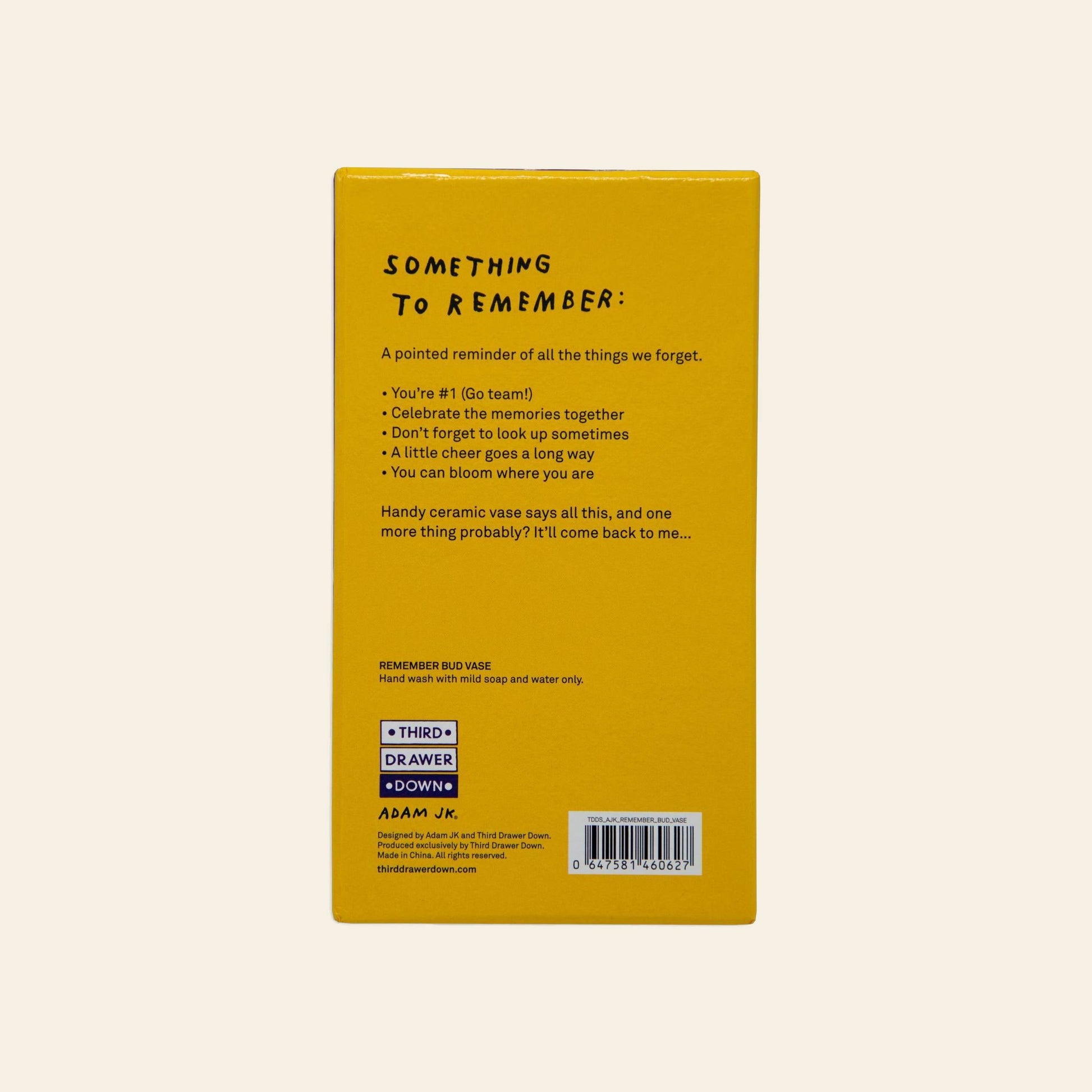 The back of the yellow Third Drawer Down Adam JK - Remember Bud Ceramic Vase box features black playful text like “celebrate memories,” cleaning tips, branding, and a barcode, all encouraging you to bloom where you are.