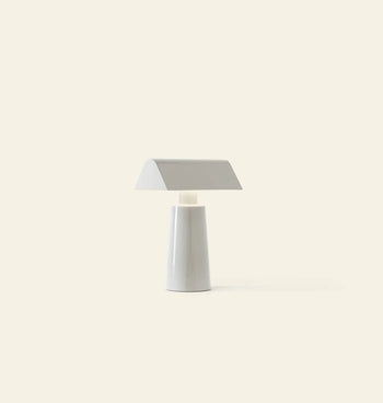 The &Tradition Caret MF1 Portable Table Lamp by &Tradition features a minimalist white design with a flat, wide rectangular shade and tapered cylindrical base, shown against a plain light beige background.