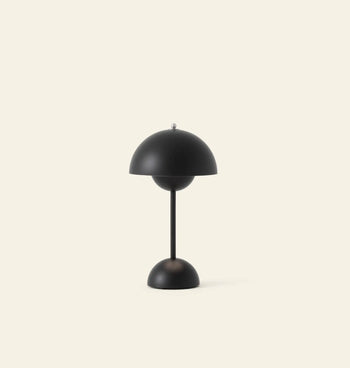The &Tradition Flowerpot VP9 Portable Table Lamp by &Tradition features a modern black dome-shaped shade and base on a slim stem, includes a USB charging cable, and is set against a plain light beige background.