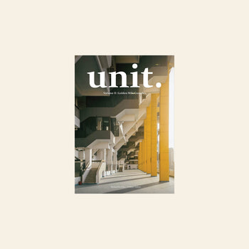 The UNIT. Volume 2: Golden Mile Complex magazine cover features a striking photo of the Golden Mile Complex, highlighting geometric stairs and yellow pillars, with sunlight streaming in.