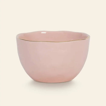 The Urban Nature Culture Good Morning Bowl features a soft pink pastel hue, a gently wavy rim, and a delicate gold edge—ideal for breakfast, styled simply against an off-white background.