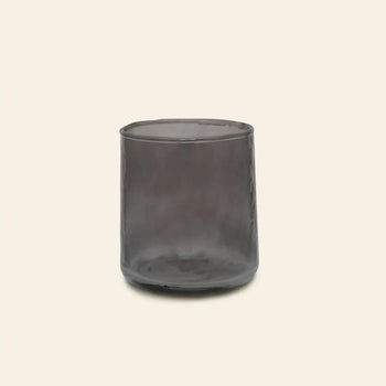 The Urban Nature Culture Tumbler Recycled Glass, in transparent smoky gray, is pictured against a plain light beige background.