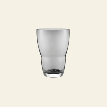 The Vipp Vipp248 Vase by Vipp, featuring a slightly curved clear glass design, is centered on a plain, light beige background, evoking minimalist decorative style.