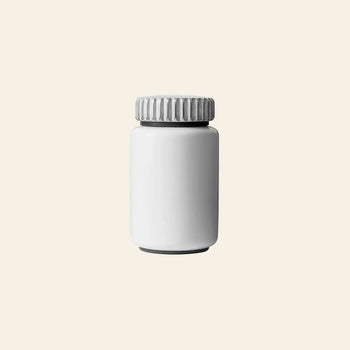 A plain, white plastic bottle with a ridged screw cap, set against a light beige background—evoking the minimalist design of the Vipp Vipp263 Salt & Pepper Mill by Vipp. The unmarked bottle echoes modern culinary aesthetics.