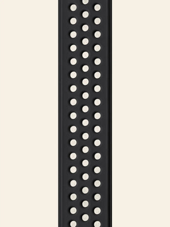 A close-up of a black silicone watch band with evenly spaced circular holes, echoing the functional design of the replaceable brush head found on the Vipp Vipp280 Dishwashing Brush by Vipp.