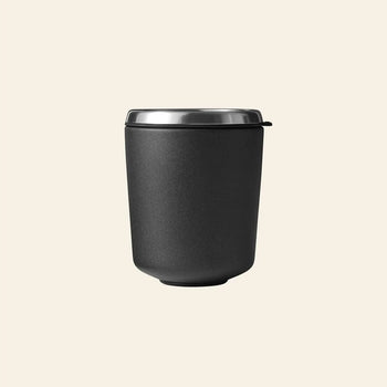 The Vipp Vipp7 Toothbrush Holder by Vipp, shown on a plain beige background, features a matte black finish with a stainless steel rim—a bathroom essential as versatile as an insulated travel mug.