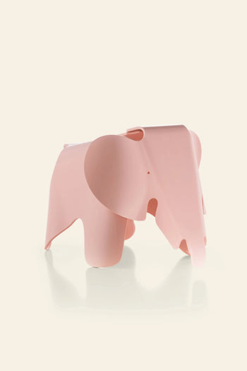 The Vitra Eames Elephant, Small by Vitra is a pink, stylized figurine with smooth, rounded edges that adds an iconic decorative touch against a plain, light background.
