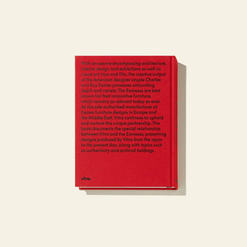 The Vitra Eames & Vitra Hardcover Book by Vitra, with a bold red cover, lies flat on a light background. Its back highlights the creative legacy of Charles and Ray Eames and their iconic furniture with the Vitra logo at the bottom.