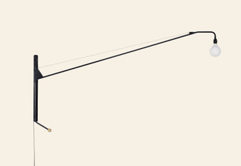 The Vitra Potence Wall Lamp - Deep Black by Vitra features a minimalist design with a long black arm and an exposed round bulb, standing out against a light background.