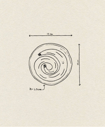 Hand-drawn sketch of the Wobbly Studio Happy Things Plate - Banane, a round plate with spiral patterns, measuring 17 cm in width and length, 1.5 cm in height. Measurement arrows on textured paper evoke the playful charm of Wobbly Studio.