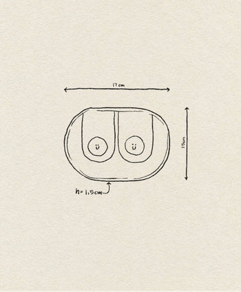 Hand-drawn sketch of two Wobbly Studio Happy Things Plate - Nénés by Wobbly Studio, side by side in an oval, each with a smiley face. Dimensions: 17cm wide, 11.5cm tall, 1.5cm high.