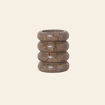 The ferm LIVING Bendum Cup by ferm LIVING is a brown cylindrical cup crafted from Brown Bidasar marble, with four rounded stacked rings that highlight its geometric form, displayed on a plain light beige background.