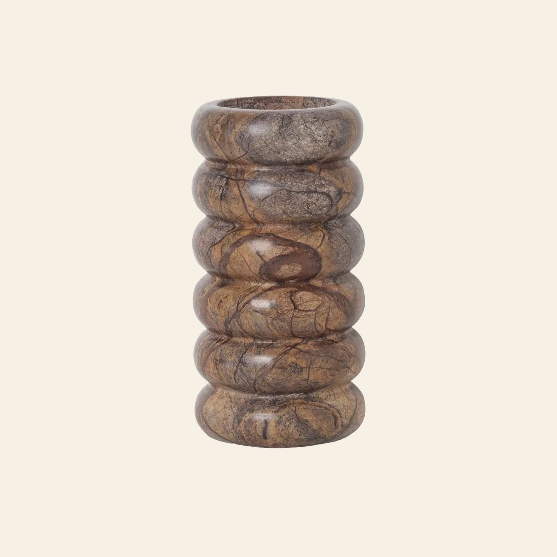The ferm LIVING Bendum Vase by ferm LIVING is a cylindrical vase crafted from Brown Bidasar marble, with a smooth, glossy finish and ridged stacked rings, set against a plain light beige background.