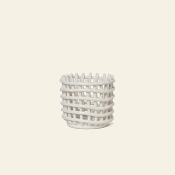 The ferm LIVING Ceramic Basket, Small, by ferm LIVING, features a white open-weave lattice design—ideal for chic storage—displayed on a plain light beige background.