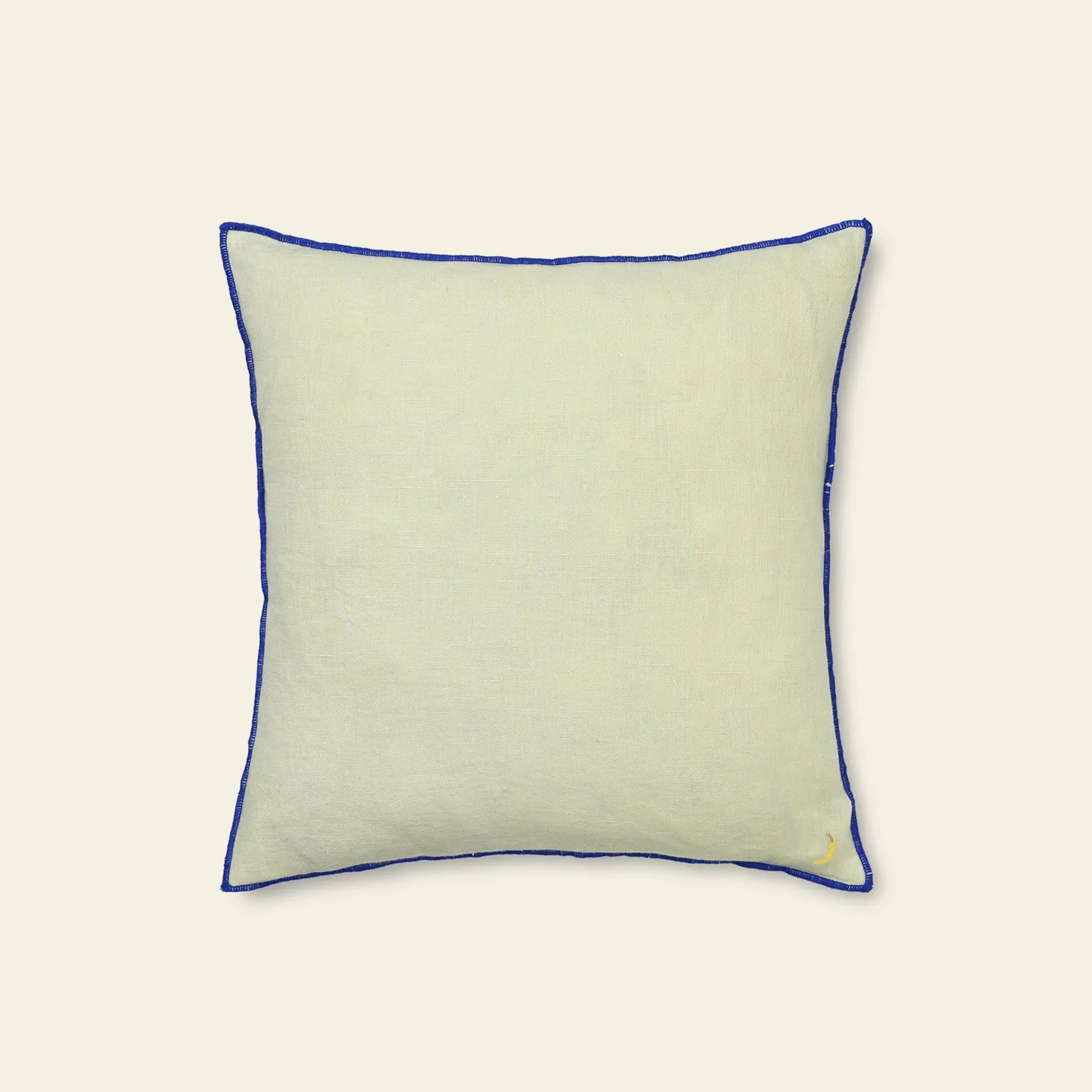 The ferm LIVING Contrast Linen Cushion is a square, light beige cushion with contrast stitching and a small fruit embroidery in one corner, shown against a plain, light background.