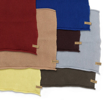 Seven GOTS-certified organic cotton ribbed knit cloths from the ferm LIVING Day Cloths Set, each labeled with a day of the week—including Monday, Thursday, Sunday, Friday, and Saturday—are shown overlapping in assorted colors.