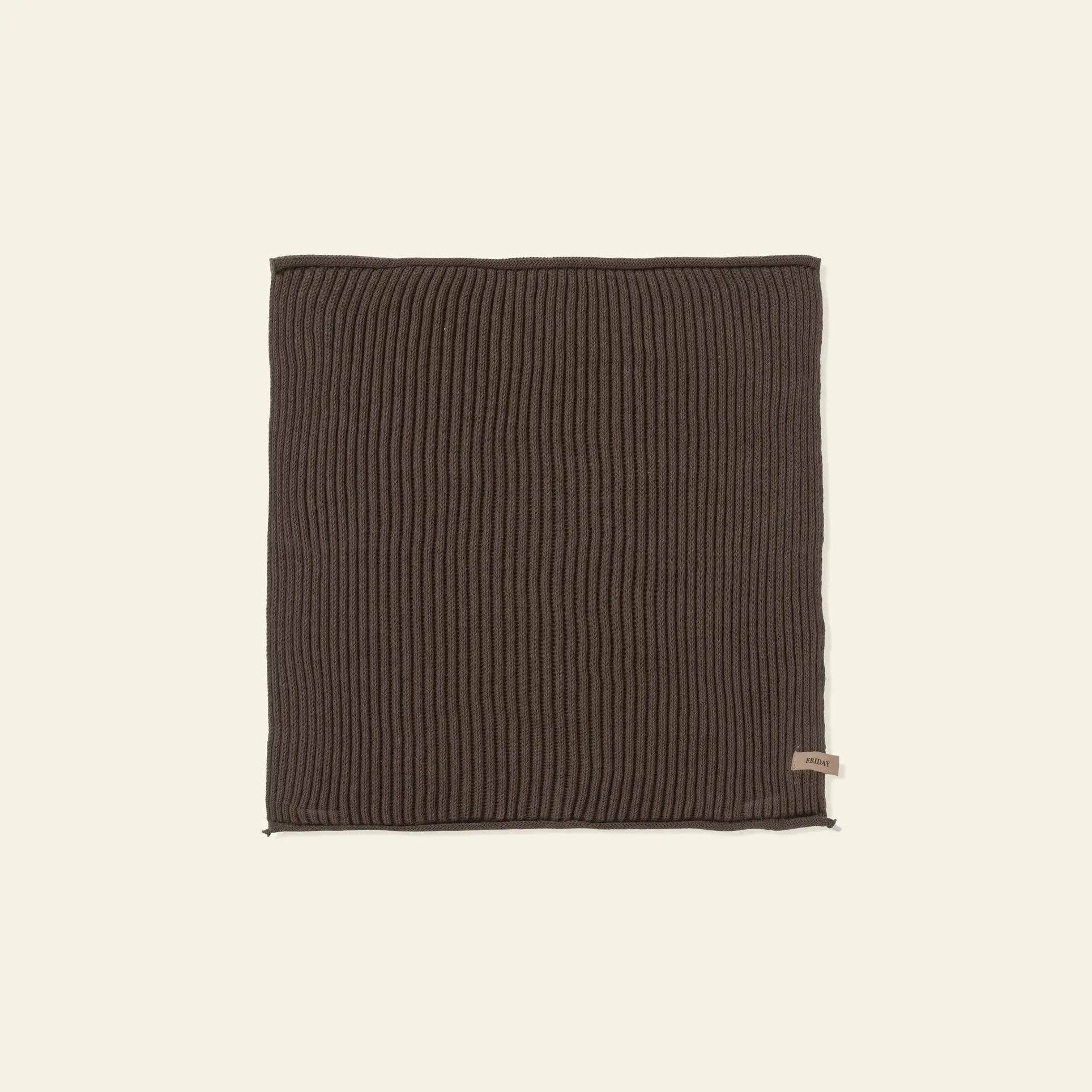 A set of ferm LIVING Day Cloths (Set of 7) in dark brown ribbed knit organic cotton is laid flat on a light beige background, with a small fabric tag attached near one edge.