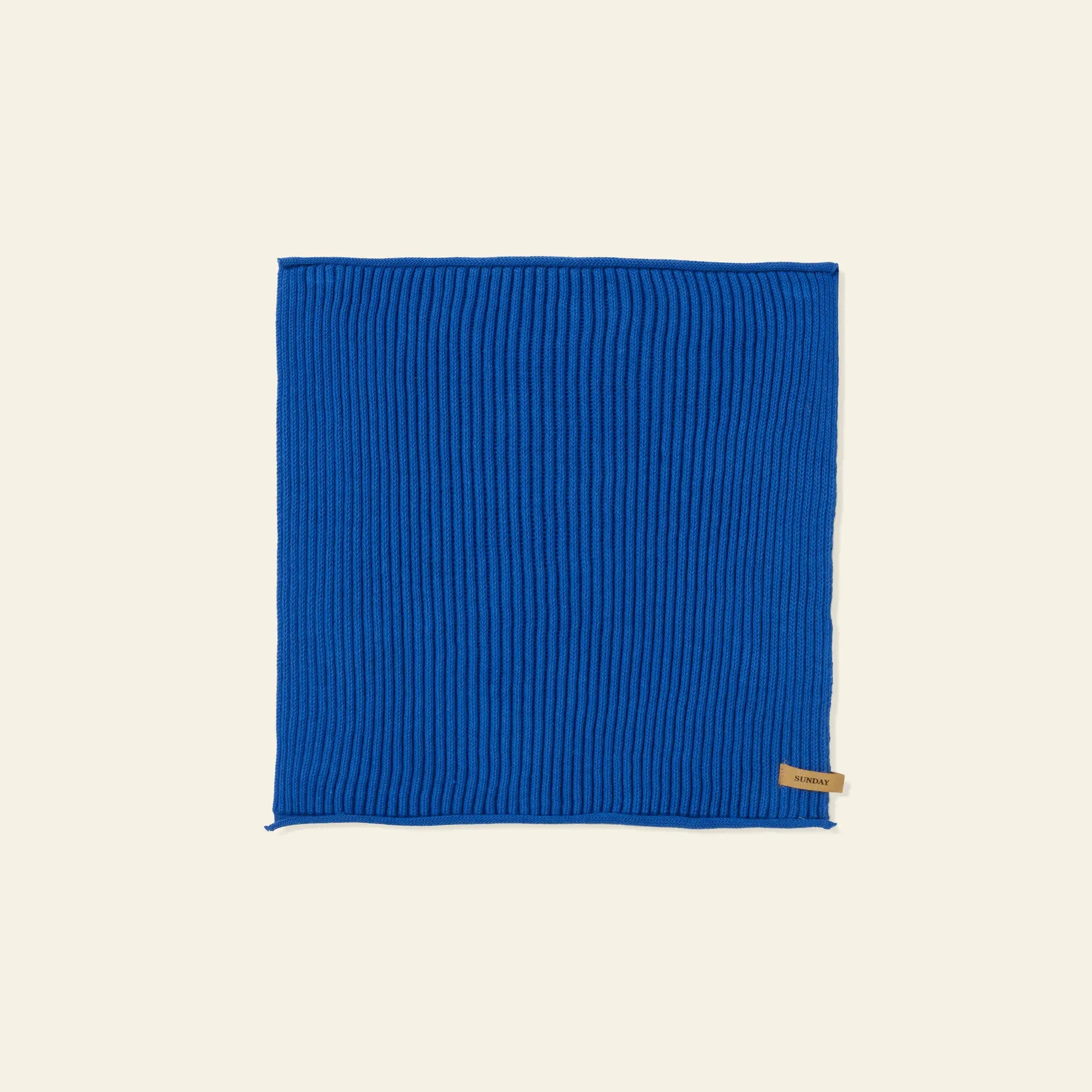 A set of seven ferm LIVING Day Cloths is arranged flat on a light beige background, each featuring a rectangular shape and subtle ribbed texture, with a small tan tag sewn onto one edge.