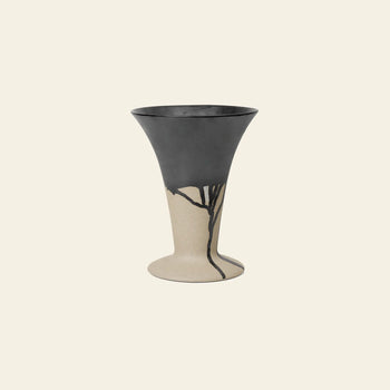 The ferm LIVING Flores Vase by ferm LIVING features a wide, flared rim and a matte black top half that fades into beige with black, branch-like lines, creating a modern tulipiere look against a light background.