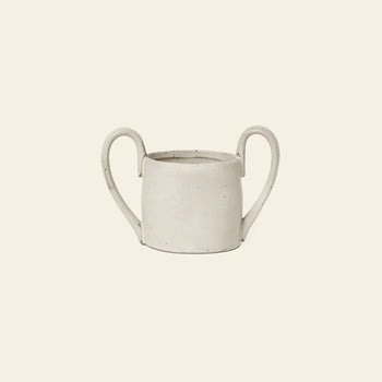 The ferm LIVING Flow Mug Mini is a minimalist, off-white ceramic mug with two large curved handles, featuring modern design by ferm LIVING and presented against a plain light beige background.