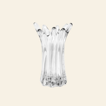 The ferm LIVING Holo Vase features an abstract, fluted design with wavy, organic edges. This clear glass vase from ferm LIVING stands upright against a simple, light backdrop, highlighting its expert craftsmanship.
