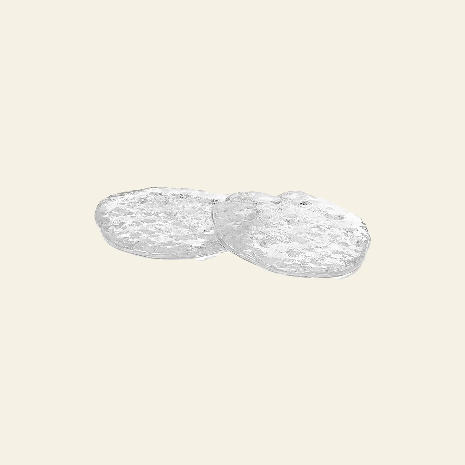 The ferm LIVING Momento Glass Stones S, Set of 2, features two small, round glass stones overlapping on a light beige background, resembling delicate decor accents that bring sophistication to any space.