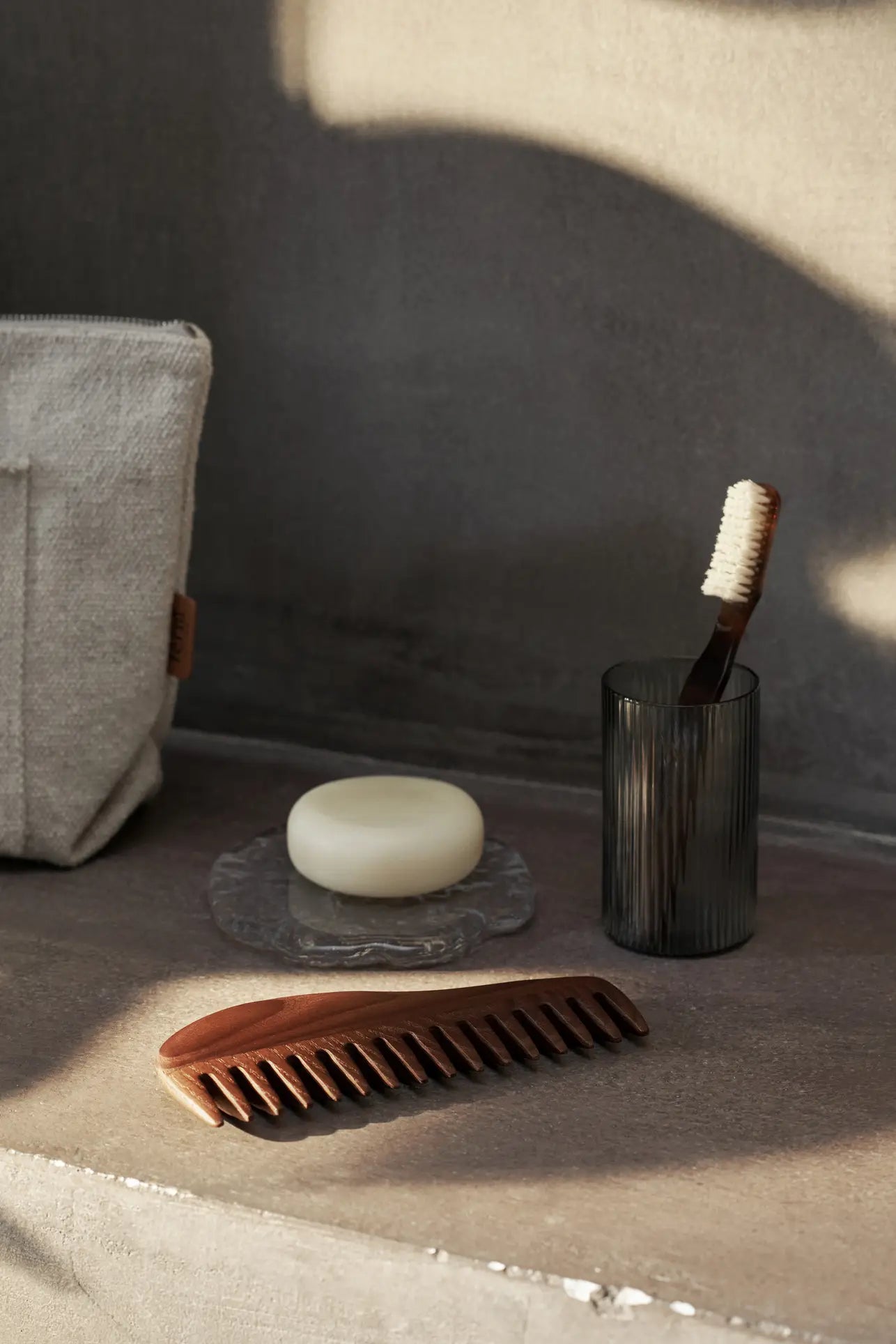 The ferm LIVING Momento Glass Stones S, Set of 2, rest elegantly on a decorative tray atop a stone countertop, adding sophisticated charm to the space in soft, natural light.