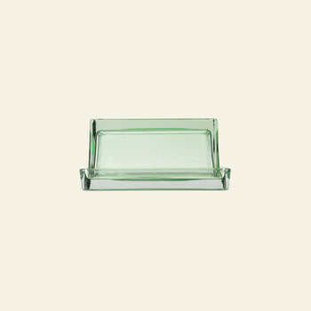 The ferm LIVING Oli Box by ferm LIVING is a rectangular, clear recycled glass soap dish with slightly raised edges, shown against a plain light beige background.