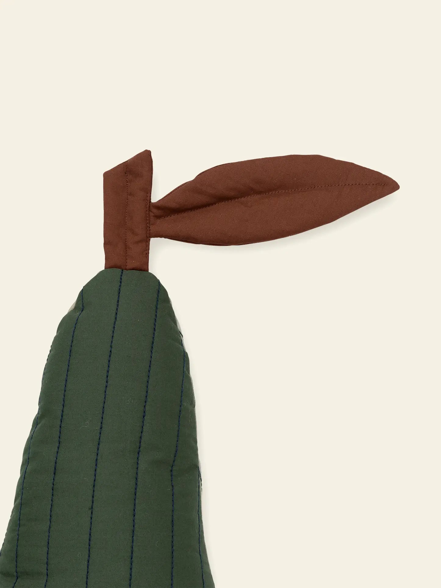 The ferm LIVING Pear Quilted Cushion, crafted from organic quilted cotton with blue stitching and a brown stem and leaf, resembles a stylized pear in soft green tones.