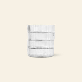 The ferm LIVING Ripple Serving Bowls, Set of 4, feature a cylindrical shape with textured horizontal ridges and vertical lines. Crafted from mouth-blown glass, these bowls are displayed upright on a plain, light beige background.