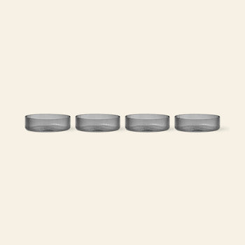 The ferm LIVING Ripple Serving Bowls, Set of 4—made from mouth-blown glass with a ribbed texture—are displayed in a row against a plain, light beige background.