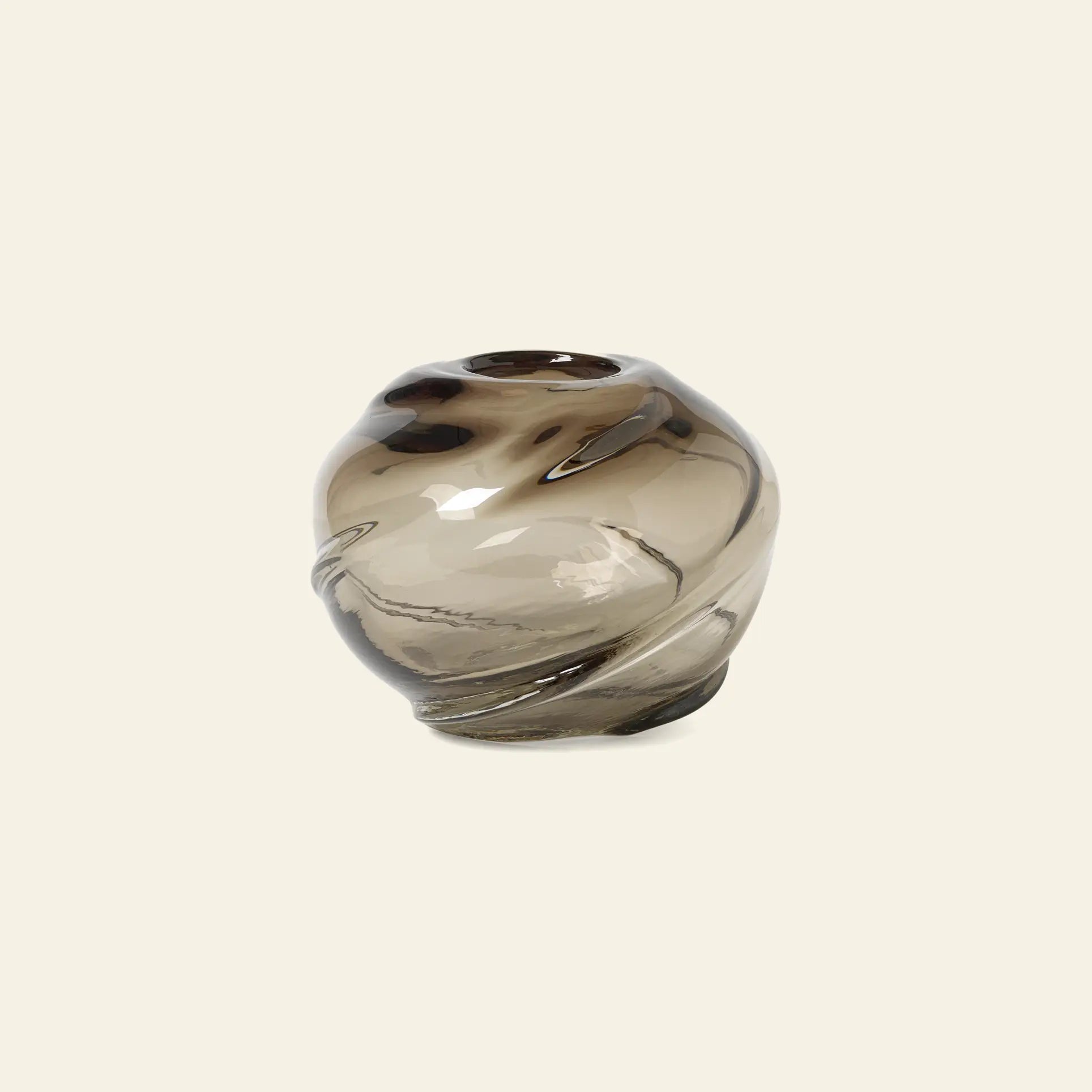 The ferm LIVING Water Swirl Vase, Round is a handcrafted, mouth-blown vase featuring smoky glass, a glossy finish, and organic wavy contours set against a plain light background.