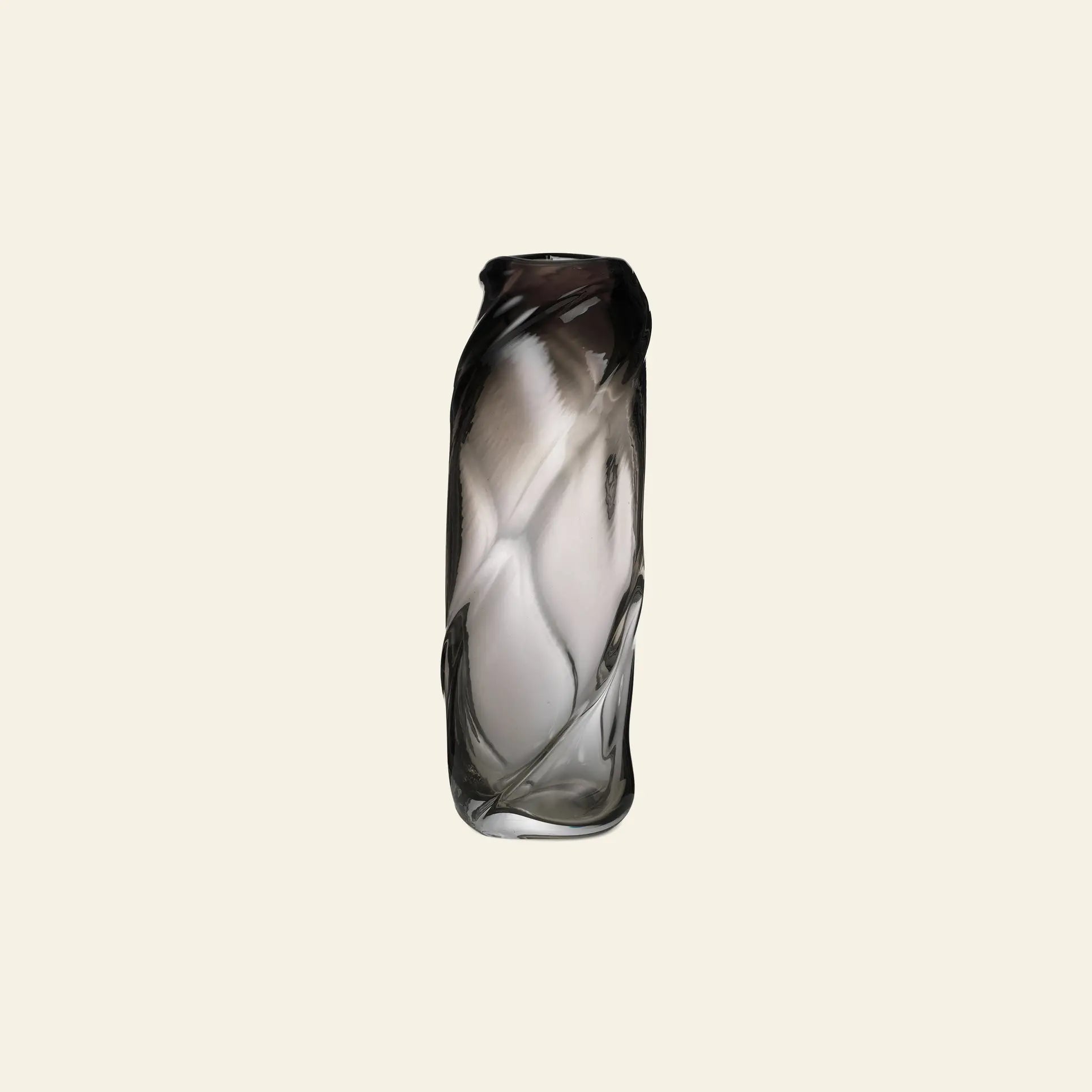 The ferm LIVING Water Swirl Vase, Tall, is a mouth-blown glass piece with a twisted cylindrical design and gradient color fading from dark to clear—perfect for displaying against a plain light background.