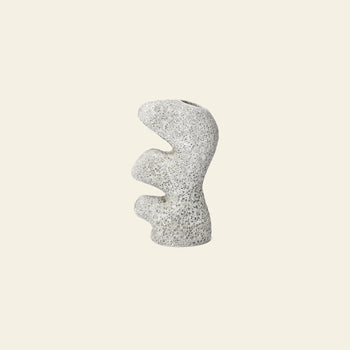 The ferm LIVING Yara Vase, Small features a sculptural, abstract design with organic wavy curves and a speckled light gray surface, from the ferm LIVING collection, shown against a plain beige background.